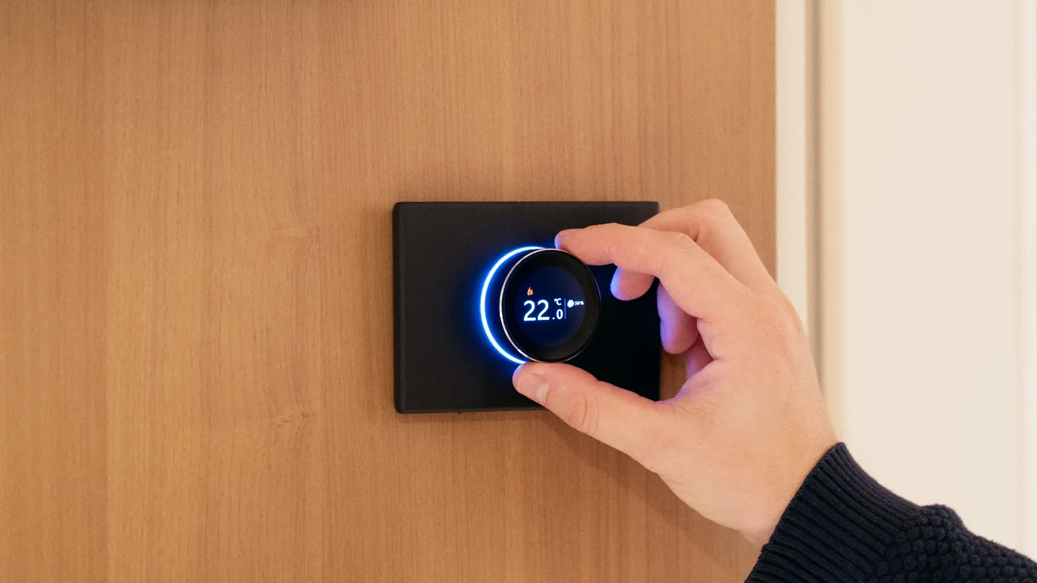 CuvThermostat nero su parete in legno, regolato a mano
